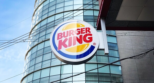 Shining Burger King logo hanging at the side of a Burger King restaurant